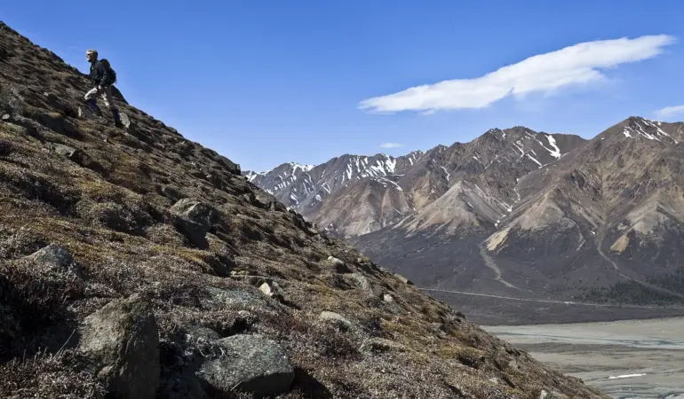 高山步道上背著背包前進的健行者