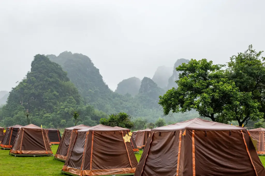 山林營地裡排列著帳篷，遠處山景被霧氣籠罩。