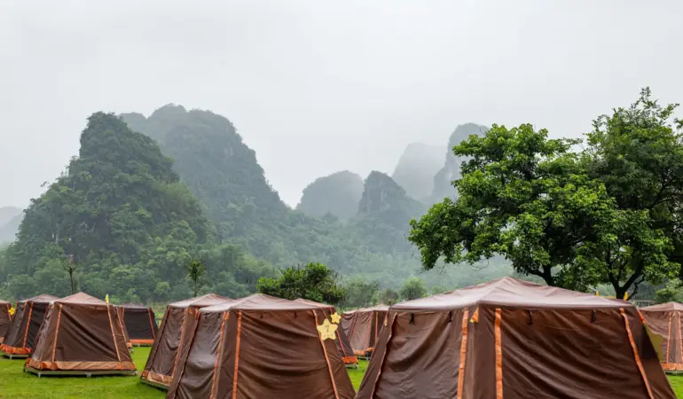 山林營地裡排列著帳篷,遠處山景被霧氣籠罩。