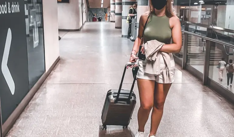 旅客在機場航廈推著行李箱,呈現登機前的旅行情境