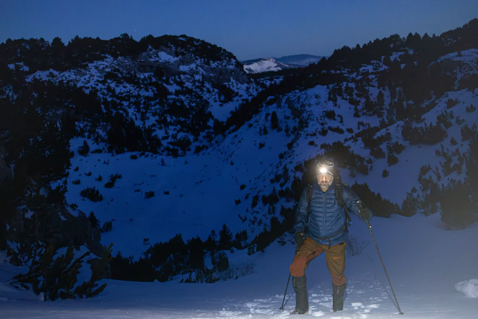 夜間步道照明 登山者在雪地步道使用頭燈前進。